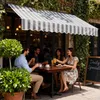 People sitting at a table outside a cafe, enjoying drinks and cake. Náhled obrázku produktu