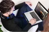 A person is using a laptop on a cooling pad while sitting on a couch. Náhľad obrázku produktu