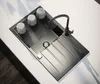 A modern black kitchen sink with a faucet and three white cups on a drying rack. Produktbild-Vorschau