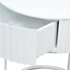 A close-up view of an open drawer on a white table. Produktbild-Vorschau