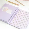 An open notebook with a purple cover and a patterned inner page, lying on a white surface with two pencils. Náhľad obrázku produktu