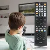 A young boy is sitting on the floor, holding a remote control and looking at a TV screen in the background. Produktbild-Vorschau