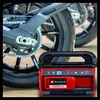 A red and black Einhell hybrid compressor is shown in front of a motorcycle wheel. Voir les images du produit