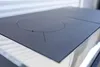 A close-up view of a black induction cooktop with silver trim. Produktbild-Vorschau