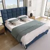 A bedroom scene with a blue upholstered bed. Produktbild-Vorschau