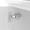A close-up view of a cabinet hinge on a white cabinet. Anteprima dell’immagine prodotto