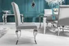 A dining room setting with a modern baroque style chair in the foreground, a dining table and chairs in the midground, and a console table in the background. Náhled obrázku produktu