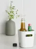 A white storage box with two bottles inside, next to a vase with greenery. Produktbild-Vorschau