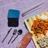 A picnic setting with food, cutlery, and reusable straws. Produktbild-Vorschau
