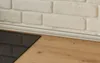 A close-up view of a kitchen countertop with a stovetop and a brick backsplash. Produktbild-Vorschau
