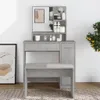 A makeup vanity with a mirror and stool, set against a white wall with a framed picture and a plant. Anteprima dell’immagine prodotto