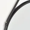A close-up view of the black metal frame of a round mirror, showing a detail of how the frame is constructed and attached. Produktbild-Vorschau