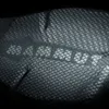 A close-up of a black fabric with a hexagonal pattern and the MAMMUT logo. Náhled obrázku produktu