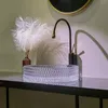 A clear glass basin sink with a black and gold faucet is displayed on a dark countertop. Produktbild-Vorschau