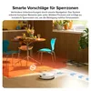 A robot vacuum cleaner is shown on a wooden floor in a dining area, with a table and chairs in the background. The image highlights the robot's ability to avoid obstacles. Produktbild-Vorschau