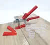 A tile leveling system with red wedges and a clear plastic leveling tool, along with clear plastic tile spacers, laid out on a wooden surface. Produktbild-Vorschau