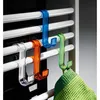 Three colorful plastic hooks are hanging on a white radiator, with one hook holding a green towel. Anteprima dell’immagine prodotto