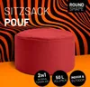 A red round pouf or ottoman in front of a black and orange striped wavy background. Produktbild-Vorschau