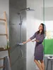 A woman is using a shower system in a modern bathroom. Produktbild-Vorschau