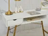 A white desk with gold legs, decorated with a lamp, vase, tray, magazine, and a small glass box. Voir les images du produit