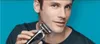A man is holding and using an electric shaver on his face against a blue background. Náhľad obrázku produktu