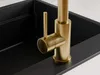A close-up shot of a gold kitchen faucet over a black sink. Produktbild-Vorschau