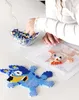 A child's hands are shown working on a perler bead project, with a bowl of beads and finished perler bead creations on a table. Produktbild-Vorschau