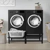 A laundry room with two black washing machines on black stands, a laundry basket, and decorative items. Podgląd zdjęcia produktu