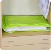 A vacuum storage bag filled with bedding is placed on a wooden shelf above drawers. Voir les images du produit