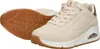 A pair of beige Skechers sneakers shown from a diagonal angle, with one shoe on its side revealing the sole. Anteprima dell’immagine prodotto