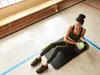 A woman is doing a workout with a medicine ball in a gym. Náhľad obrázku produktu