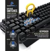 Close-up of a black mechanical keyboard with some keys removed to show the blue switches and a yellow keycap puller. Produktbild-Vorschau