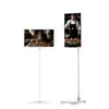 Two white stands with screens displaying a chef cooking. Produktbild-Vorschau