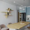 A modern kitchen island with chairs and a wall-mounted shelf unit. Voir les images du produit