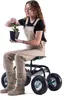 A woman is sitting on a garden stool with wheels and holding a potted plant. Podgląd zdjęcia produktu