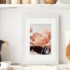 A framed picture of pink roses displayed on a marble countertop in a kitchen setting. Anteprima dell’immagine prodotto
