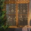 Christmas lights in the shape of stars hanging in a window next to a Christmas tree. Produktbild-Vorschau