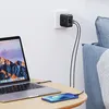 A UGREEN 66W PD wall charger is plugged into a wall outlet, charging a laptop and a smartphone on a wooden table. Anteprima dell’immagine prodotto