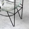 Close-up of the base of a glass beverage dispenser with a black metal stand. Produktbild-Vorschau
