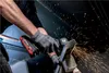 A person is using a cordless angle grinder to cut metal, with sparks flying. Podgląd zdjęcia produktu