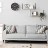 A living room scene with a gray sofa, decorative pillows, shelves with decor, and a wall clock. Anteprima dell’immagine prodotto