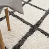 A close-up view of a shaggy rug with a diamond pattern. Produktbild-Vorschau