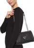 A woman wearing a black dress and a black Guess handbag. Produktbild-Vorschau