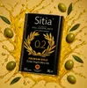 A can of olive oil is surrounded by splashing olive oil and olives. Produktbild-Vorschau