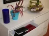 A white dresser with decorative items and an open drawer. Produktbild-Vorschau