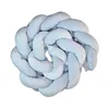 A braided pillow in a light blue color, presented in a circular, knotted formation. Voir les images du produit