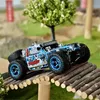 A remote-controlled off-road truck is driving over a wooden bridge in an outdoor setting. Produktbild-Vorschau