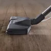 A close-up of a vacuum cleaner attachment on a wooden floor. Produktbild-Vorschau