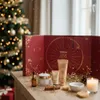 A Christmas advent calendar and beauty products are displayed on a wooden table in front of a decorated Christmas tree. Produktbild-Vorschau