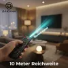 A hand holding a remote control in a living room setting, with a beam of light emanating from the remote. Produktbild-Vorschau
